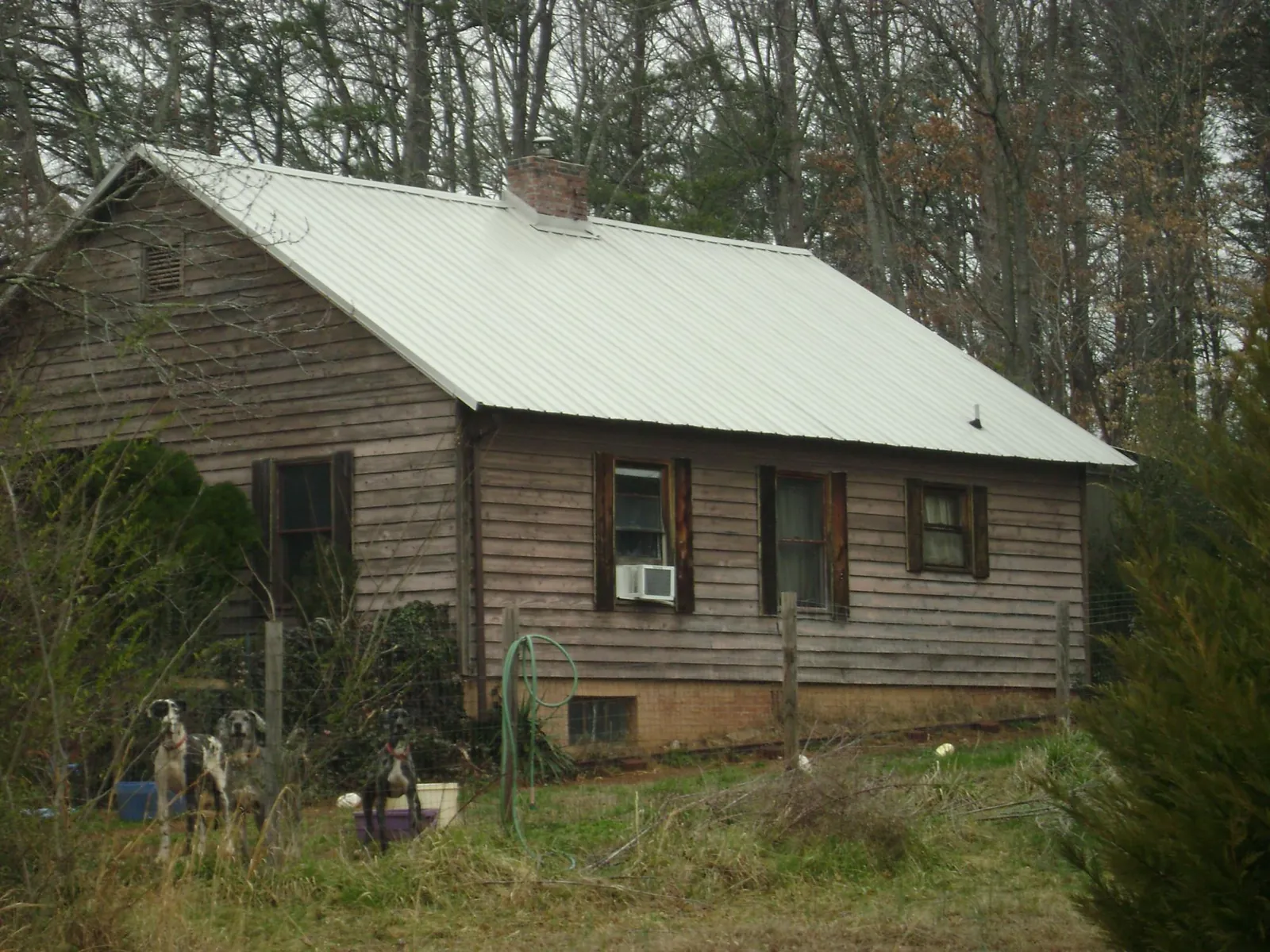 White metal roof on an old wood sided farmhouse, from a Metal Roof Installation job in Loganville